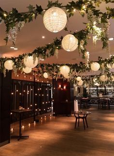 a room filled with lots of lights and greenery hanging from the ceiling above it