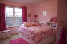 a bedroom with pink walls and carpeted flooring