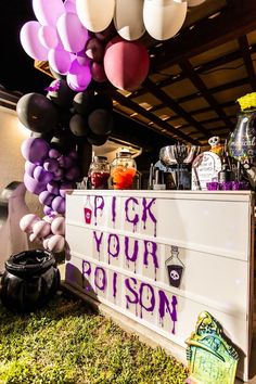 a sign that says pick your poison next to some balloons and other items on the ground