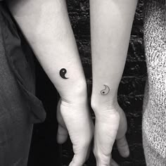 two people with matching tattoos holding hands