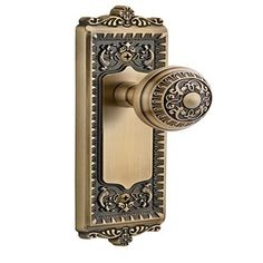 an antique style door handle with a keyhole and ornate design on the front plate