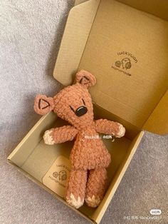 a brown teddy bear sitting inside of a box