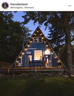 a small blue cabin with lights on the windows