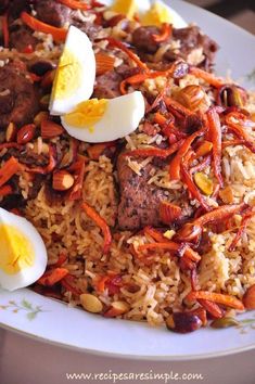 rice, meat and eggs are served on a plate