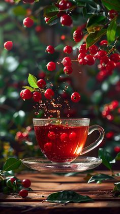 a glass cup filled with liquid sitting on top of a wooden table next to berries