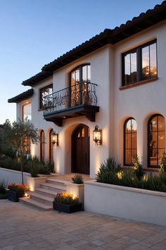 a house that is lit up at night with lights on the windows and steps leading to it