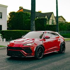 a red sports car parked on the side of the road in front of a house