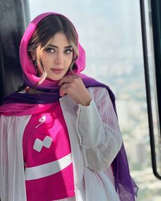 a woman wearing a pink and white scarf