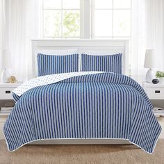 a blue and white bed in a bedroom