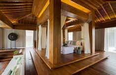 a bedroom with wooden flooring and white bed in the middle, surrounded by windows