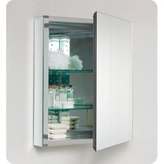 an open medicine cabinet with glass shelves and white towels on the bottom shelf in front of it