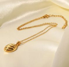 Elevate your style with our Gold Oval Croissant Wave Pendant Necklace, featuring a unique croissant-inspired oval pendant with a graceful wave design. This contemporary piece blends modern artistry with classic elegance, perfect for any occasion. Add a touch of sophistication to your accessory collection with this distinctive and chic necklace. Made with stainless steel base with a thick layer of high quality 18k gold plating ensuring lasting quality.  This product is waterproof, tarnish-free, sweatproof, and has a 1 Year Warranty.  Although our pieces are Waterproof and tarnish free, we recommend keeping them as dry as possible so they can stay golden and last you many years.   Every order comes with a Nazzar branded custom soft microfiber cloth which can be used to clean and restore shin Wave Pendant, September Birthstone Jewelry, Stay Golden, Chic Necklace, August Birthstone Jewelry, July Birthstone Jewelry, Gold Jewelry Necklace, Zodiac Jewelry, Jewelry Ring Box