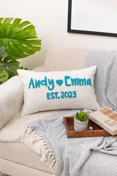 the personalized pillow is on top of a couch next to a potted plant