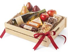 a wooden crate filled with assorted fruit and wine, along with a red ribbon