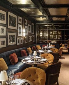 an empty restaurant with many tables and chairs in front of the wall full of pictures