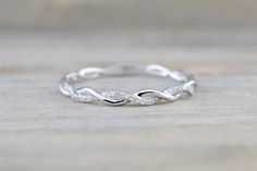 a white gold wedding band with two diamonds in the shape of an intertwined knot