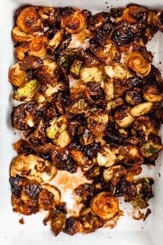 a square white plate topped with brussel sprouts