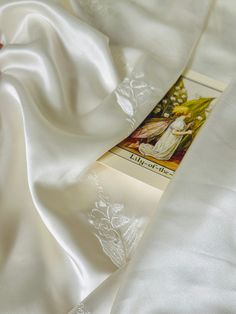 the white sheets are folded up on top of each other with an image of a woman