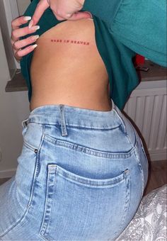 a woman with her back turned to the camera and has an inscription on her stomach