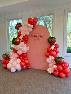 the balloon arch is decorated with strawberries and strawberrys for a berry first birthday party