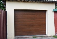 a brown garage door in front of a red brick building