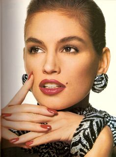 a woman posing with her hand on her chin and wearing statement earrings, black and white dress