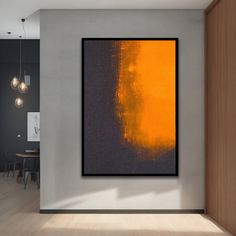 an orange and black painting hanging on the wall