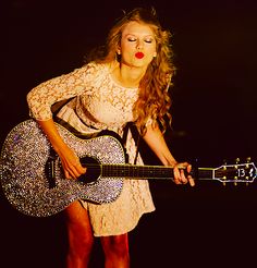 a woman holding a guitar in her right hand