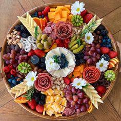 a bowl filled with lots of different types of fruit and veggies on top of a wooden floor