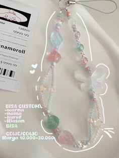 the necklace is made with glass beads and multicolored stones, along with a tag