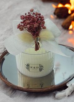 a vase with flowers in it sitting on a plate next to a fire place setting