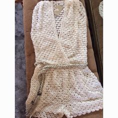 a white crocheted dress sitting on top of a couch