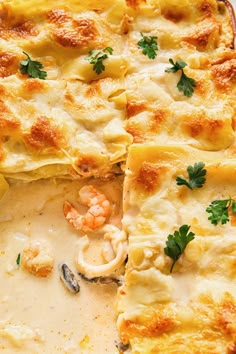 a casserole dish with shrimp and cheese on the side, ready to be eaten