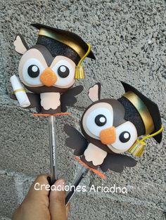 there are two cake toppers made to look like penguins with graduation hats on them