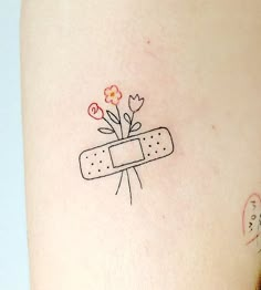 a woman's leg with a tattoo on it that has a band aid and flowers