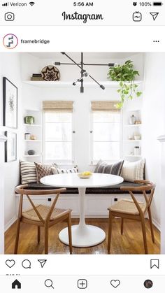 a white table and chairs in a room with wooden floors, windows, and shelves