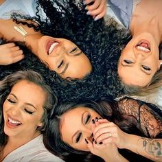 three beautiful women laying on top of each other in the middle of a circle with their heads together