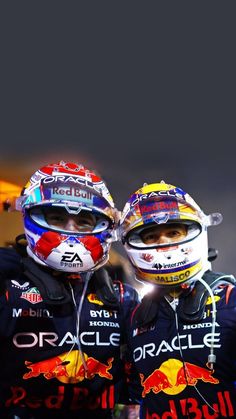 two red bull racing drivers posing for a photo with their helmets on and looking at the camera