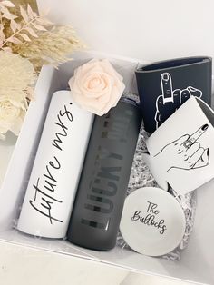 an open box with personal items in it and flowers on the table next to it