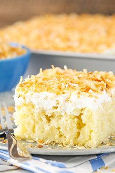 a close up of a piece of cake on a plate with a fork and bowl in the background