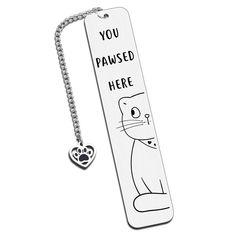 a bookmark with a cat on it that says you paws here and a heart hanging from the front