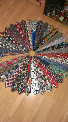 a bunch of ties laid out in a circle on the floor next to each other