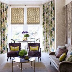 a living room with couches, chairs and a table in front of a window