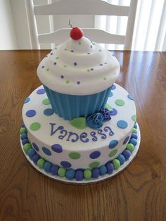 a cupcake decorated with polka dots and a cherry sits on top of the cake