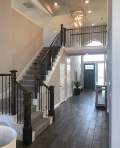 a staircase leading up to the second floor in a home with wood floors and white walls