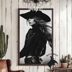 a black and white photo of a woman with long hair wearing a cowboy hat in a living room