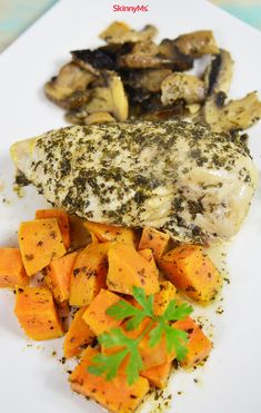 a white plate topped with chicken, carrots and mushrooms covered in seasoning on top of it