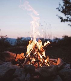 a campfire is lit up in the evening