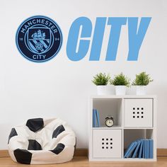 the manchester city wall sticker is next to a book shelf