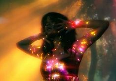 a woman with her hands on her head and lights all over her body in front of her